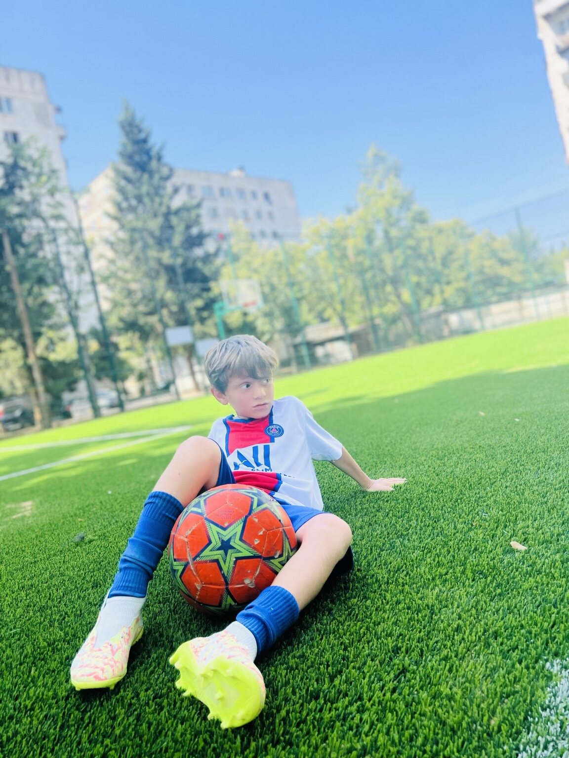 Sandro Abesadze sitting with a football during a sunny training session