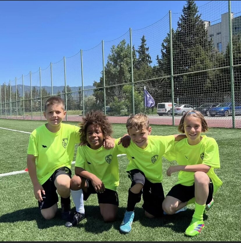 Sandro Abesadze and three teammates posing in their bright team shirts