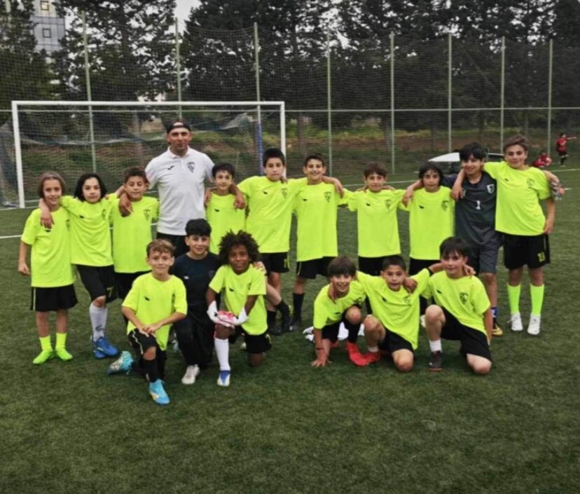 Sandro Abesadze posing with his youth football team and coach