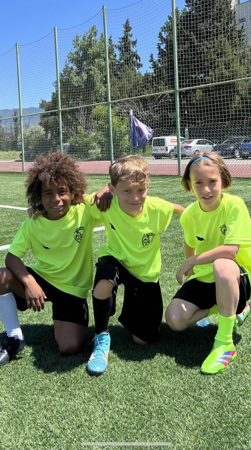 Sandro Abesadze kneeling with two teammates on the pitch